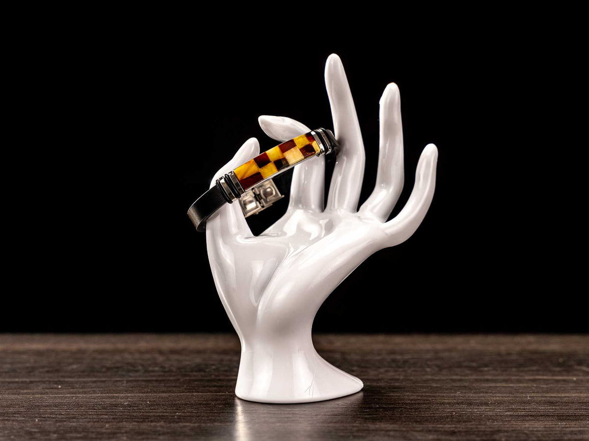 Real Baltic amber mosaic bracelet displayed on white ceramic hand mannequin showing perfect fit, silver accents and elegant design – premium wearable jewelry.