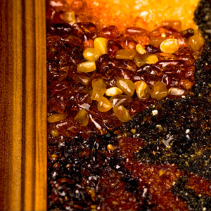 Extreme close-up of BalticBliss genuine amber artwork showing a cluster of natural polished Baltic amber stones and fine amber grain texture, highlighting premium Lithuanian handmade amber craftsmanship and exquisite detail.
