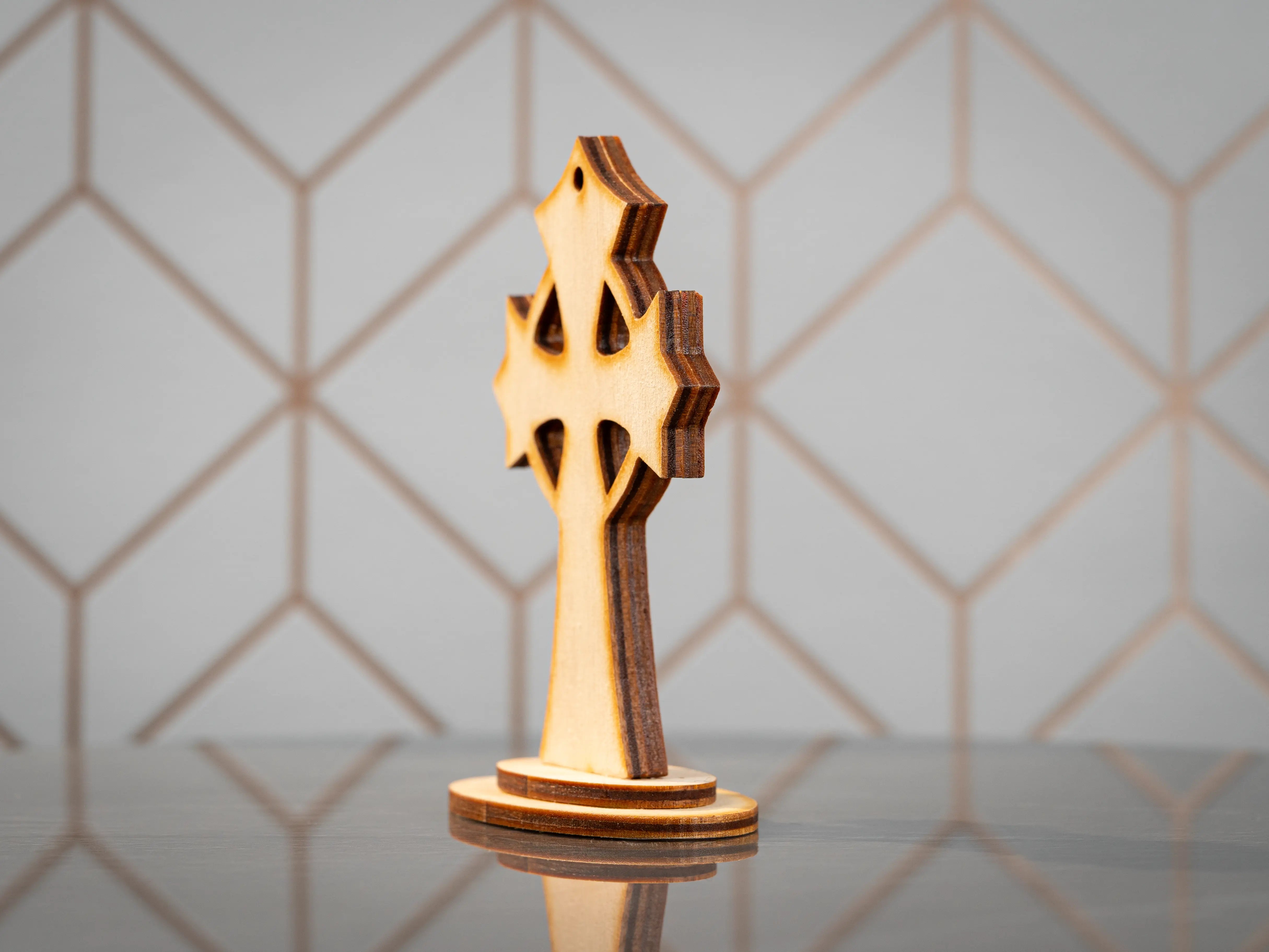 Side view of BalticBliss genuine amber wooden Celtic cross on stand, layered Baltic birch construction with natural amber inlay, authentic Lithuanian handmade amber cross religious décor souvenir.